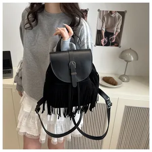 Close-up of black fringe bucket bag detail with leather flap and silver buckle