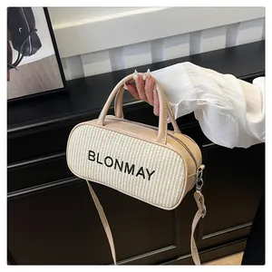 Detail of beige cylinder bag with woven texture, leather handles and silver zipper