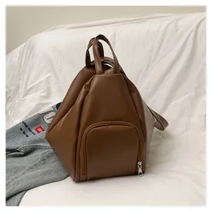 Detailed close-up of brown geometric faux leather backpack with silver zipper pocket