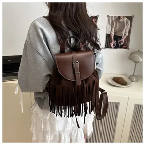 Detail view of coffee brown fringe backpack featuring retro buckle and layered tassels