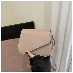 Detail of beige faux leather crossbody bag featuring Fashion Trend printed lettering