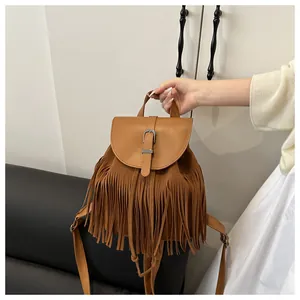 Close-up of brown fringe backpack with metal buckle and vintage bohemian suede texture