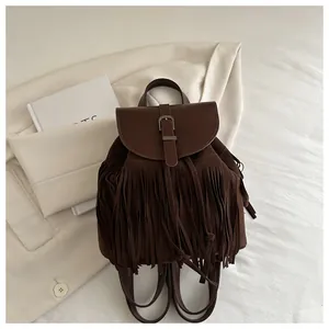 Detailed view of dark brown suede tassel backpack with vintage metal buckle and handle