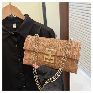 Detail of vintage woven straw handbag with herringbone pattern and gold chain strap