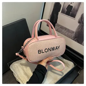Detail of pink baguette bag with woven texture and embroidered logo in gift box
