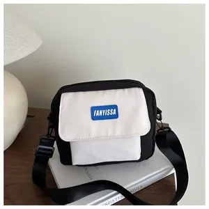 Détail du petit sac bandoulière bicolore en toile avec bandoulière large réglable