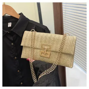 Detailed close-up of straw woven small square bag with gold interlocking buckle and chain