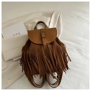 Detail of a brown fringe backpack with bohemian tassels and leather flap closure