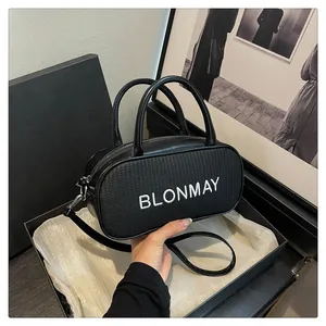 Detail of black woven leather handbag featuring white BLONMAY embroidery and metallic hardware