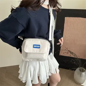 Petit sac carré beige à bandoulière avec poche zippée et sangle large pour look décontracté