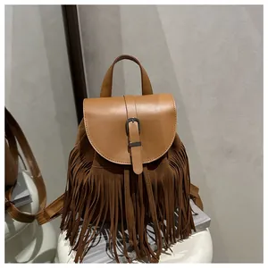 Detailed view of dark camel bohemian tassel backpack with fringe and metal buckle closure