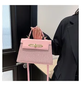 Detailed view of pink handbag with glitter finish and golden metal twist lock closure