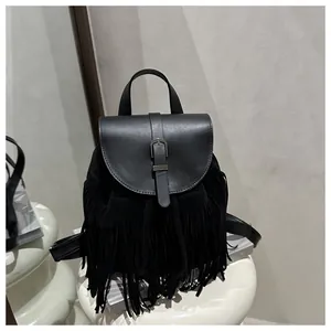 Detail of a black leather fringe backpack showing smooth texture and silver buckle