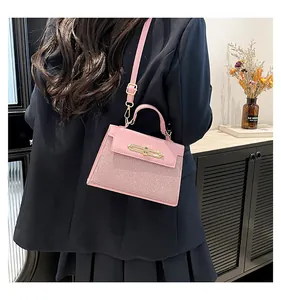 Pink patent leather crossbody bag with metallic clasp shown on a model in an indoor setting