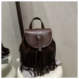 Macro detail of dark brown bucket bag with fringe tassels and metallic buckle closure