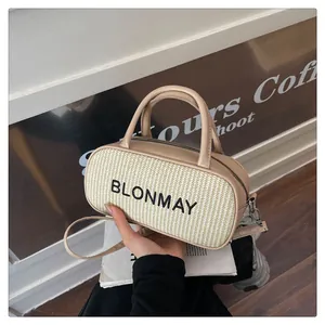 Detailed macro of woven straw texture and dual handles on beige baguette bag