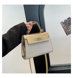 Detail of champagne gold handbag with metallic clasp and glitter textured paneling