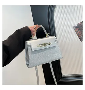 Detailed view of silver sequin handbag featuring a metallic twist lock and elegant texture
