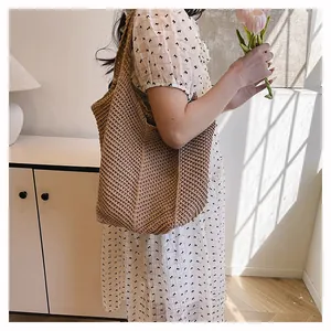 Gros plan d'un sac cabas en paille kaki avec texture tissée et bandoulière bohème