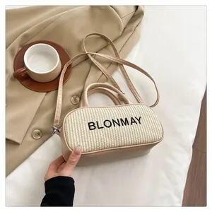 Detailed close-up of straw and leather handbag featuring black BLONMAY embroidery
