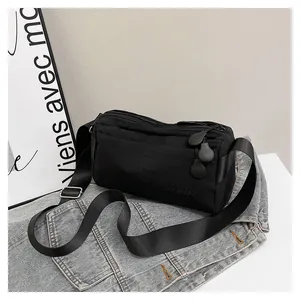 Détail du sac bandoulière noir en nylon avec sangle réglable et logo DUONING