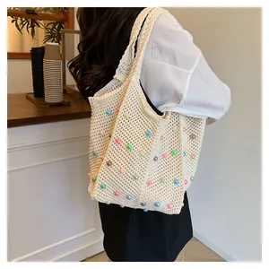 Detail of hand-woven beige tote bag featuring colorful candy beads and openwork texture