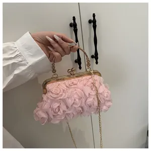 Dettaglio dei petali di rosa 3D in chiffon rosa e cornice dorata di una borsa da sera