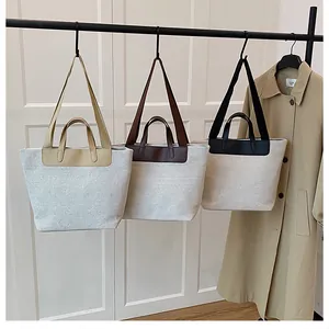 Detailed shot of canvas tote bags in yellow, brown, and black with leather handles