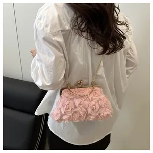 Dettaglio della borsa da sera con petali di rosa rosa e tracolla a catena d'oro