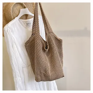 Gros plan du sac fourre-tout en crochet kaki avec large poignée et texture ajourée