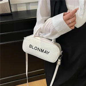 White woven cylinder baguette bag with leather straps and black logo for women