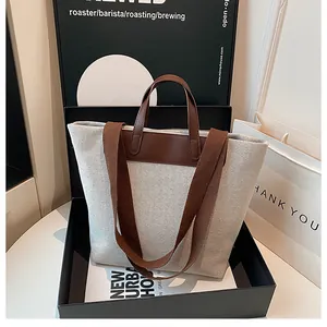 Detail view of canvas and leather tote bag in gift box with shoulder strap and handles