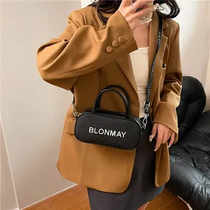 Minimalist black baguette handbag with top handles and adjustable shoulder strap for women