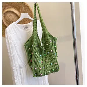 Detail of woven straw green tote bag with colorful pearls and thick knit texture