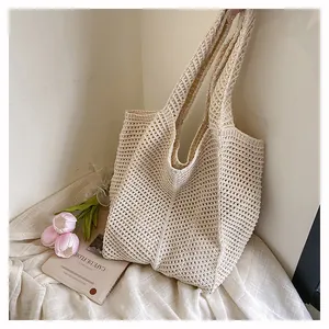 Détail macro du sac cabas en maille crème avec motif tressé évidé et texture