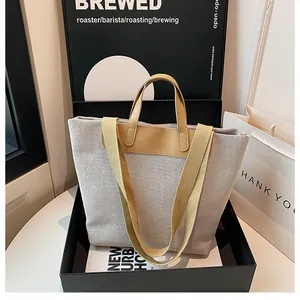 Detail of minimalist canvas tote with premium leather handles and wide shoulder straps