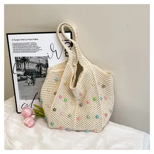 Close-up of cream crochet tote bag with colorful faux pearls and floral tulip decor