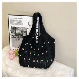 Close-up of black crochet tote bag with colorful beads and knit texture detail