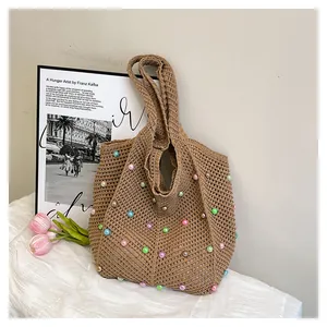 Close-up of brown crochet tote bag with colorful pearls and hollow woven texture