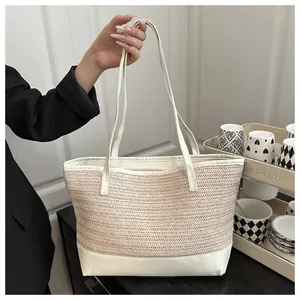 Detail of minimalist straw tote bag with cream V-weave texture and white leather handles