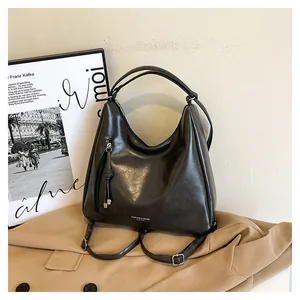 Close-up of black PU leather backpack with tassel detail and polished metal zipper
