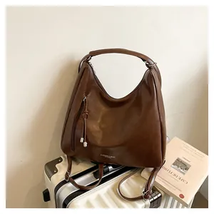 Detail of dark brown retro leather handbag with Fashion & Bags text on white suitcase