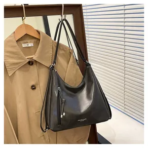 Close-up of the black shiny PU leather bag featuring a zipper knot and fashion text print