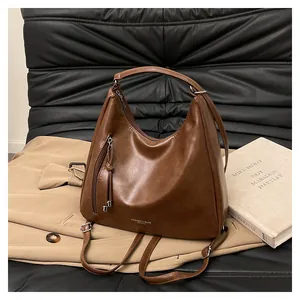 Detail view of brown leather hobo bag with fringe zipper and adjustable strap