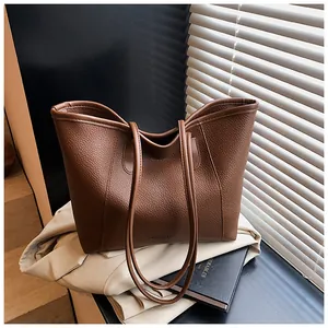 Close-up of brown litchi pattern leather texture on a stylish large capacity tote bag