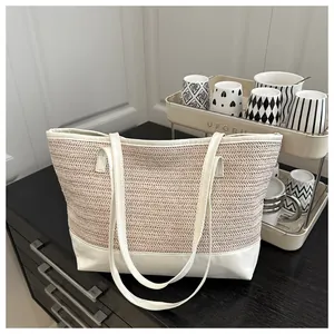 Detail of herringbone straw weaving and cream leather stitching on the large tote bag