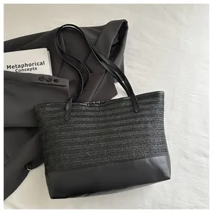 Close-up of contrast straw woven and smooth leather texture on black tote shoulder bag