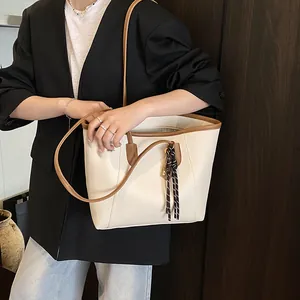 Retro tote bag in beige lychee leather with caramel contrast straps and woven pendant