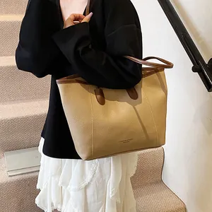 Fashionable large capacity tote bag with lychee texture and brown handles in a minimal setting