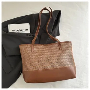 Top view of large straw tote bag with brown faux leather trim on woven texture